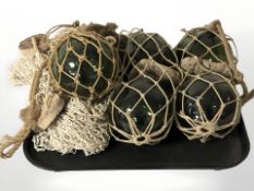 A group of green glass fishing floats and netting.