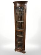 A reproduction single door corner cabinet with shelved interior,