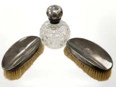 A cut crystal silver-mounted dressing table flask, together with two silver-backed brushes.