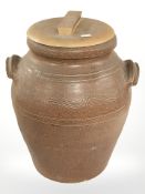 An earthen ware crock pot with wooden lid,