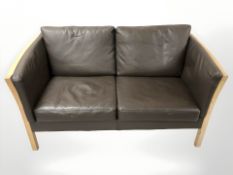 A late 20th century Danish wooden framed two seater settee, upholstered in brown stitched leather,