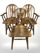A set of three oak wheelback armchairs.