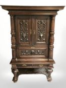 A continental heavily carved oak double door cabinet, 117 cm W x 67 cm D x 172 cm H.