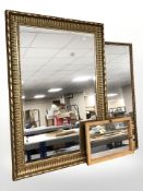 A reproduction gilt and bevelled mirror, 107 cm x 76 cm, and two smaller mirrors.