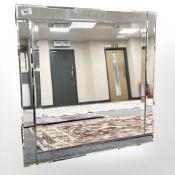 A contemporary all glass mirror, 61 cm x 61 cm.