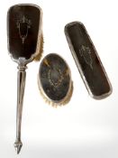 Three silver-mounted tortoiseshell dressing table brushes.