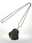 A carved malachite pendant depicting Buddha suspended on Sterling silver chain,