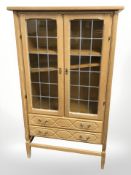A 20th century Danish blond oak bookcase, with stained leaded glass doors,