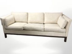 A late 20th century Danish wooden framed three seater settee, in cream upholstery,