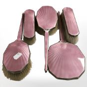 A silver and pink guilloche enamel five piece dressing table brush and mirror set, Birmingham marks,