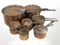 A group of 19th century graduated steel-handled copper saucepans with lids, largest 52 cm long.