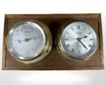A brass cased barometer and eight day timepiece mounted on board, width 26 cm.