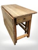 A 19th century pine gate leg kitchen table, extended 107 cm W x 98 cm D x 74 cm H.