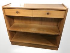 A contemporary teak bookcase fitted two drawers,