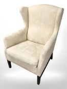 A late 20th century Danish wooden framed wingback armchair, in cream upholstery, width 75 cm.
