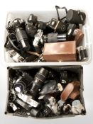 A large quantity of cameras and lenses including Praktica, Polaroid, Minolta, etc.