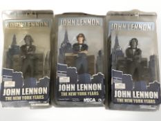 Three Neca John Lennon The New York Years figurines, in original packaging.