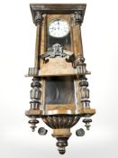 An early 20th century Vienna wall clock, with pendulum and weights,