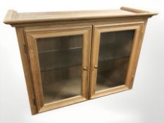 A glazed pine double door cabinet, width 89 cm.
