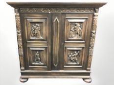 A continental heavily carved oak double door side cabinet, 150 cm W x 50 cm D x 152 cm H.