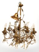 A decorative gilt metal chandelier with glass droplets