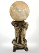 A figural pottery lamp base in the form of three cherubs, with mottled globular glass shade,
