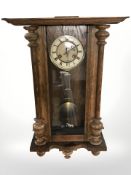 A Junghans oak wall clock, with pendulum and key, length 71 cm.