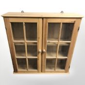 A glazed pine double door wall cabinet with shelved interior, 96 cm W x 27 cm D x 94 cm H.