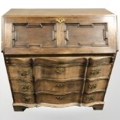An early 20th century continental oak serpentine front bureau, 104 cm W x 51 cm D x 104 cm H.