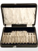 A set of twelve silver-handled cake knives and forks, in fitted case.