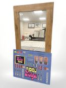 A contemporary oak mirror, 60 cm x 120 cm, together with a glass fruit machine panel 'Nippy Nudger'.