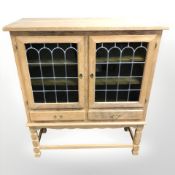 A 20th century Danish blond oak side cabinet with stained leaded glass doors,