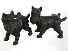 Two painted metal figures of scottie dogs.