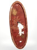 A Japanese lacquered oval panel depicting a geisha, 92 cm x 36 cm.