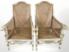 A pair of painted and gilt bergere open armchairs,