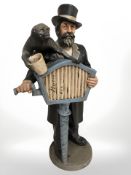 A painted composition figure of a street performer with music box and monkey, height 62 cm.