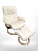 A Norwegian Ekornes stressless cream leather reclining swivel armchair and matching footstool.