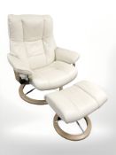 A Norwegian Ekornes stressless cream leather reclining swivel armchair and matching footstool.