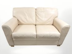 A contemporary cream stitched leather two seater settee,