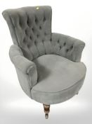 An early 20th century armchair reupholstered in grey buttoned fabric and a further 20th century