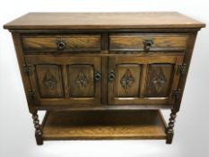 A reproduction carved oak sideboard, 107 cm W x 41 cm D x 92 cm H.