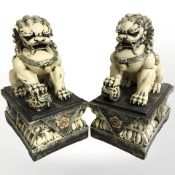 A pair of modern oriental resin temple dogs on stands, height 42 cm.