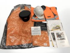 A group of railway high visibility clothing, hard hat and cap, metal railway signs.
