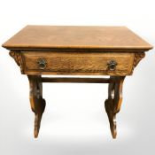 A reproduction carved oak single drawer side table, 71 cm W x 44 cm D x 75 cm H.