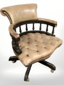 A tan leather swivel captain's desk chair,