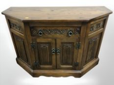 A reproduction oak linen fold low side cabinet, 100 cm W x 44 cm D x 71 cm H.
