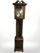 A reproduction oak linen fold eight day long-case clock, with pendulum and weights,