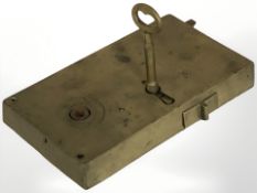 A 19th century brass door lock, with key, width 20 cm.