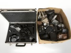 A collection of vintage cameras and an aluminium camera case containing a Tamashi camera with