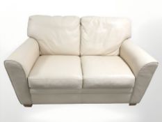 A contemporary cream stitched leather two seater settee,
